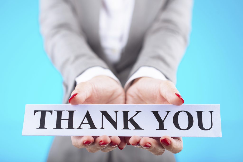 Hand of business lady showing card with thank you message